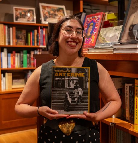 Shelby holding up a book in the shop